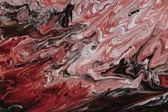 Remolinos de tinta roja, blanca y negra que se mezclan