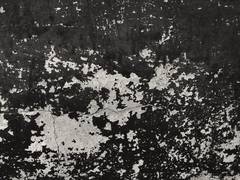 Pared negra con manchas de pintura blanca descascarada