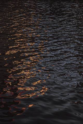 Reflejos naranjas sobre agua oscura