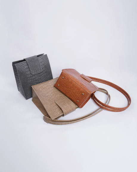 Tres bolsos de cuero grabado, gris, arena y cobre, sobre fondo claro
