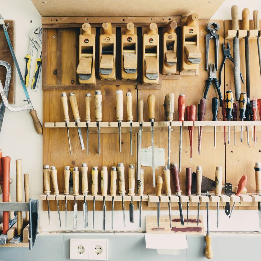 Pared de un taller con cepillos, formones y serruchos colgados