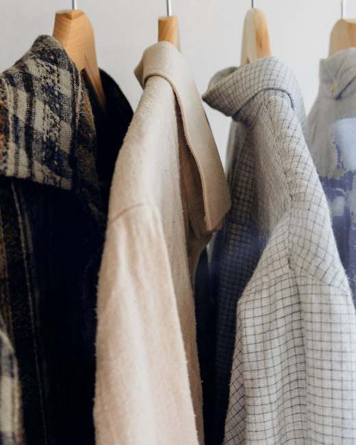 Camisas de cuadros y de lino colgadas en fila