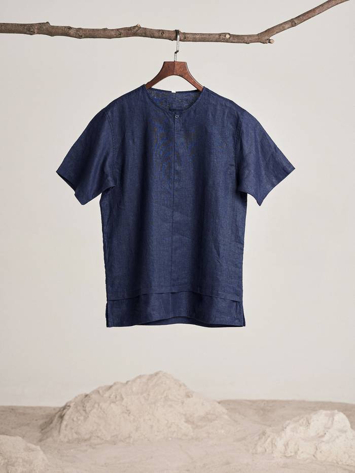 Camisa de lino azul noche colgada de una rama
