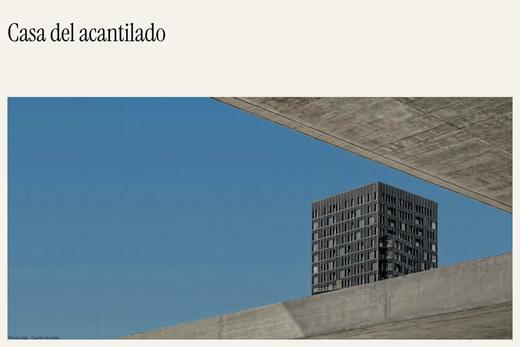 Fotografía de una casa de hormigón con cielo claro y dos líneas de texto