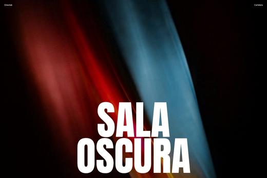 Fotografía de una luz de colores sobre negro con el título «Sala oscura»