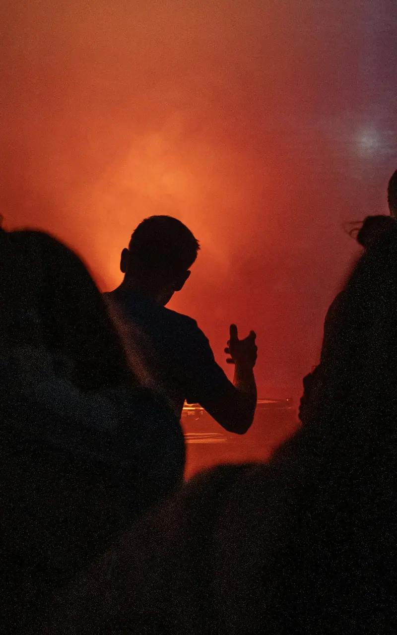 Siluetas de público entre humo rojo
