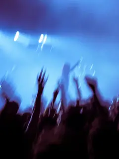 Manos en alto entre luces azules