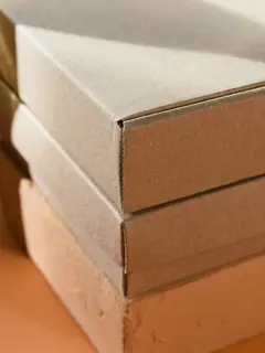 Cajas de cartón apiladas sobre un fondo anaranjado