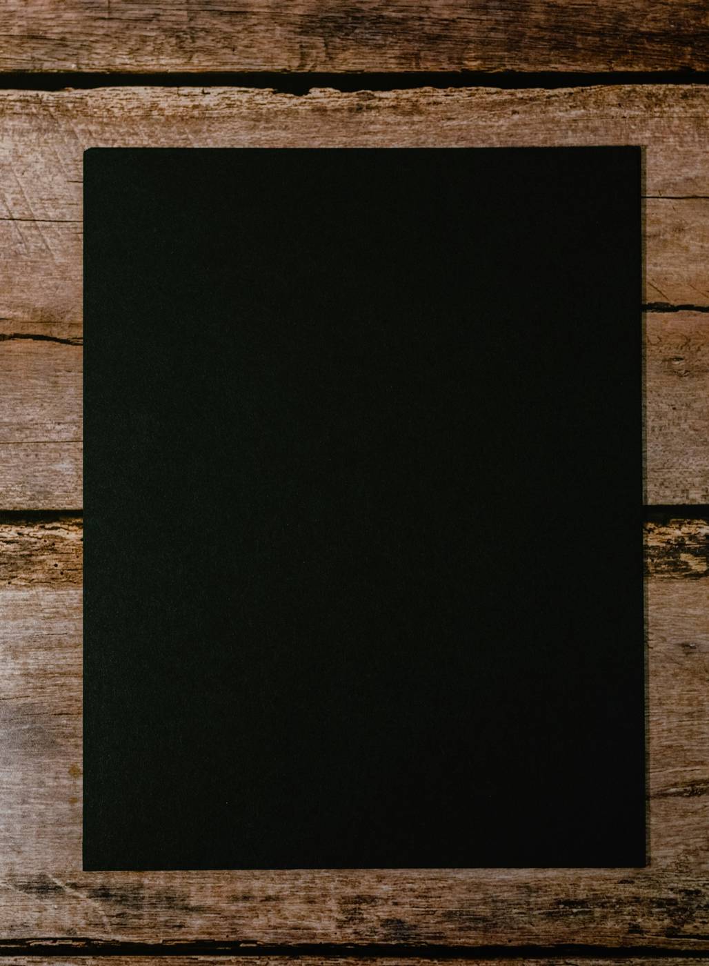 Carta negra sobre una mesa de madera oscura