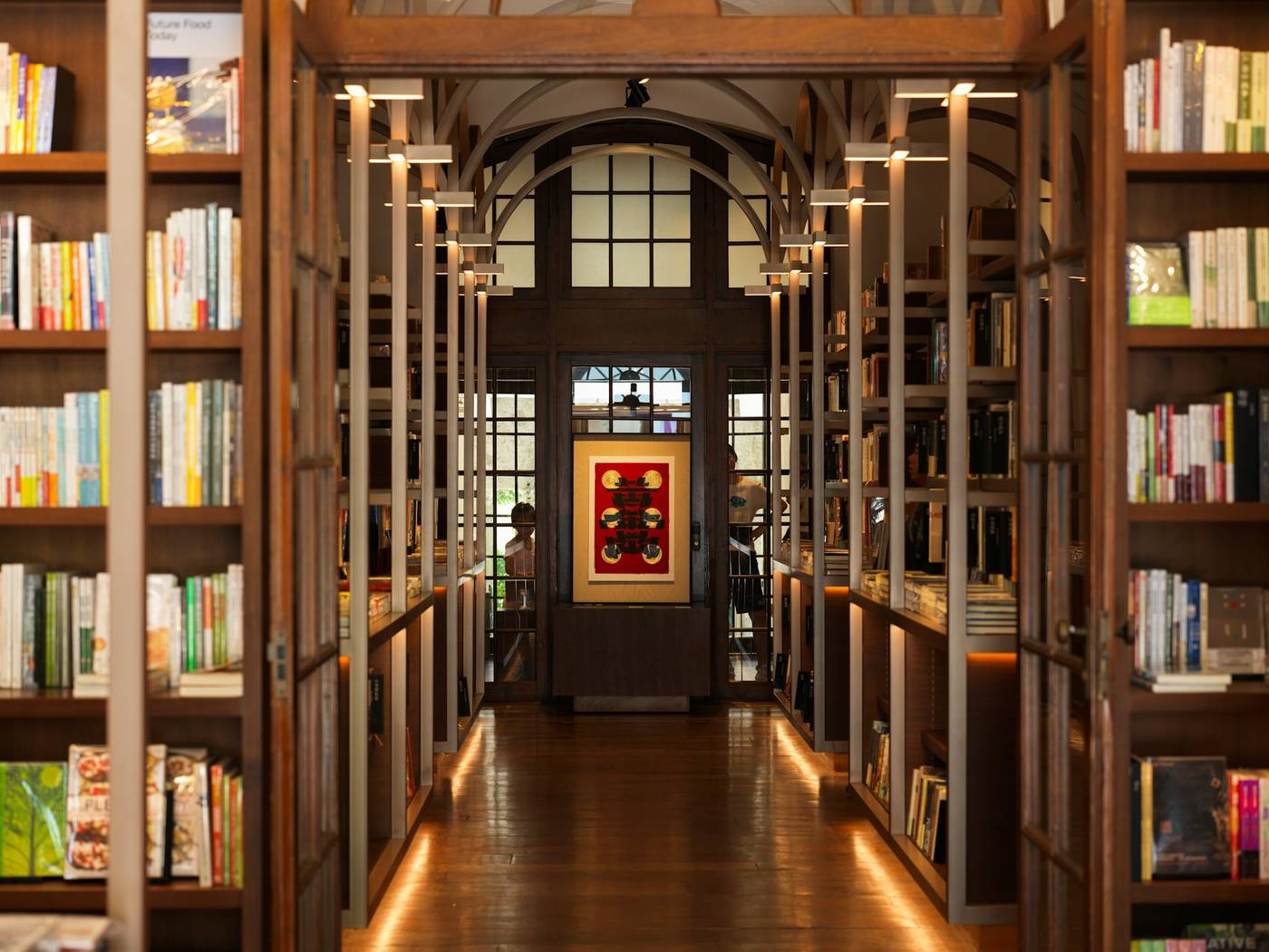 Pasillo de una librería con estantes de madera llenos de libros