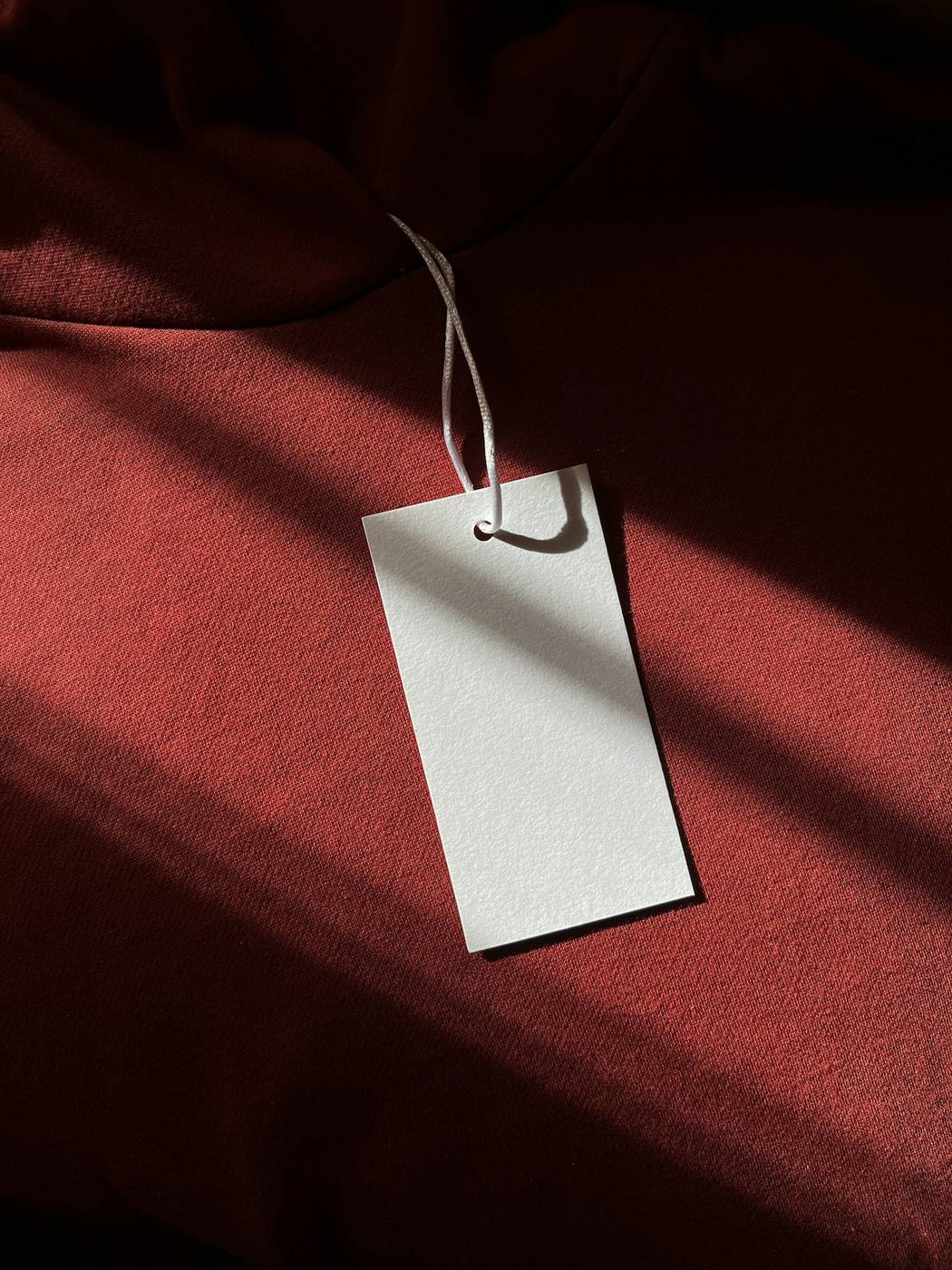Etiqueta blanca con cordel sobre una tela roja