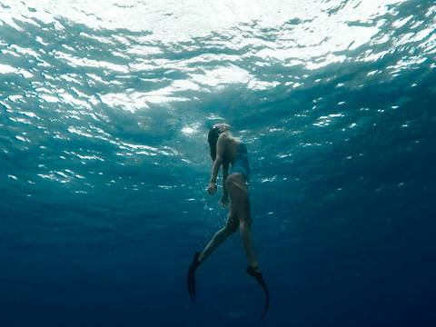 Nadadora bajo la superficie brillante del mar