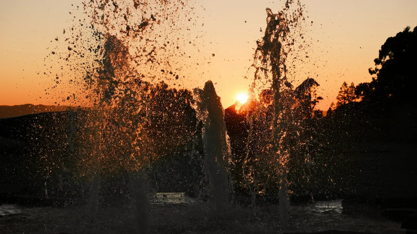 Salpicaduras de una fuente a contraluz al atardecer