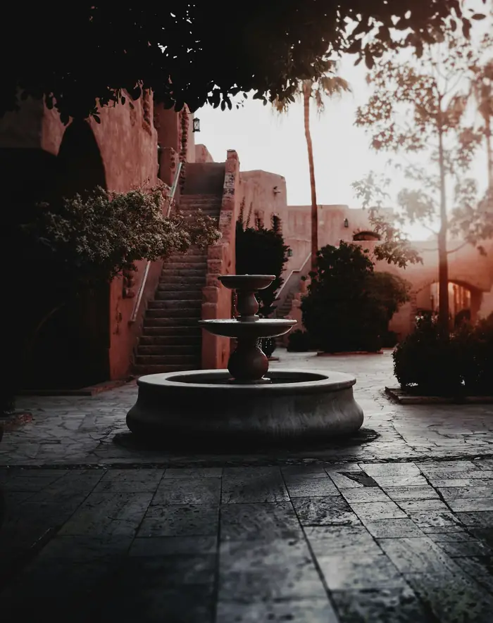 Fuente en un patio de terracota al atardecer