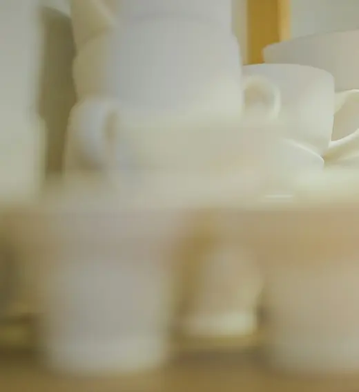 Tazas de cerámica blanca sobre un estante de madera