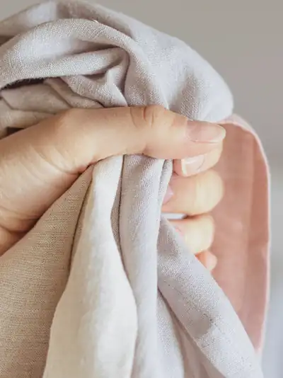 Una mano sostiene una tela de lino clara