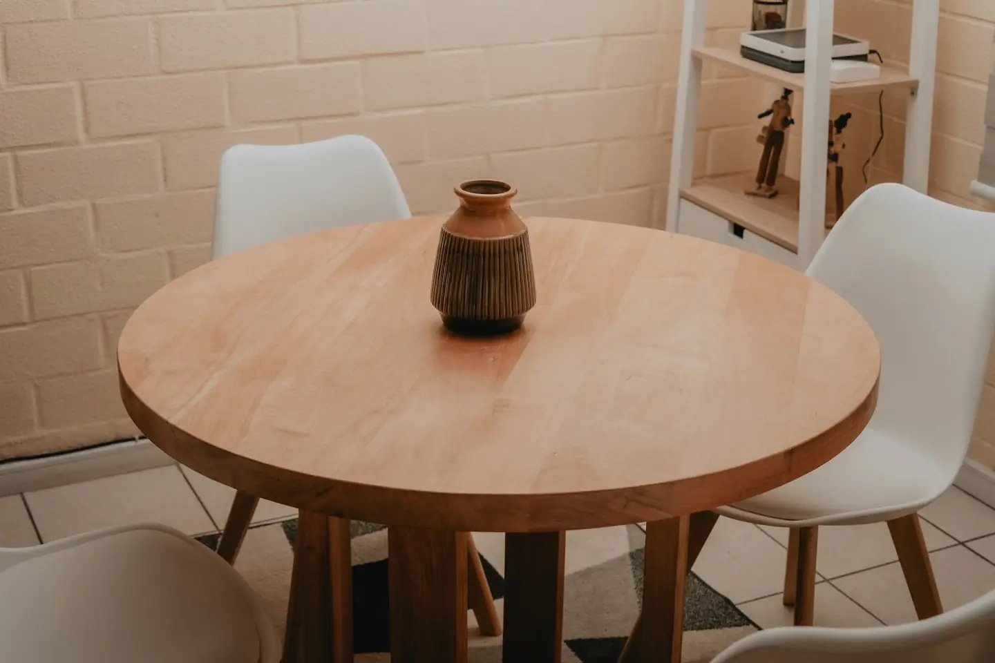 Mesa redonda de madera con sillas blancas