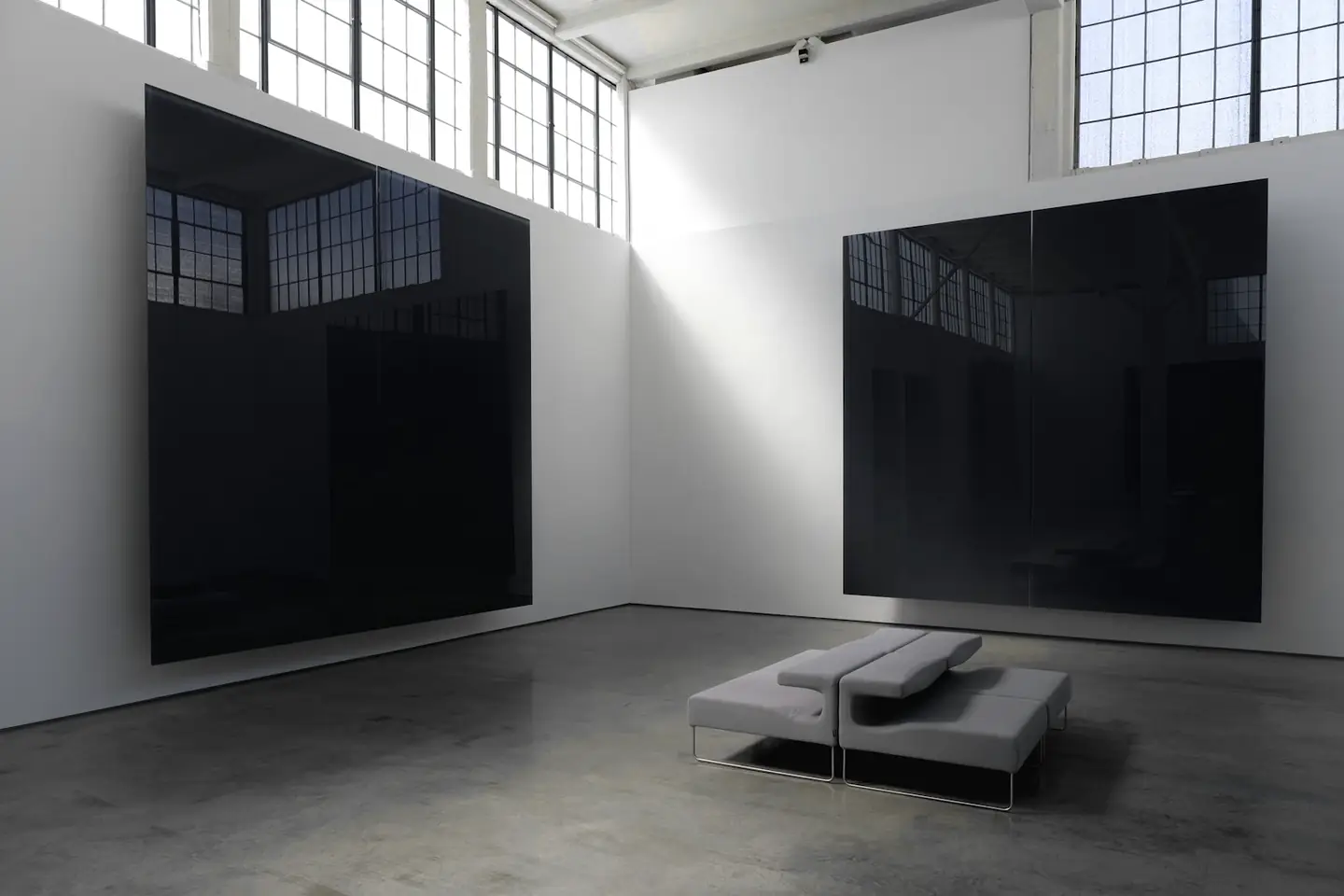 Sala con dos paneles negros y una banca gris baja
