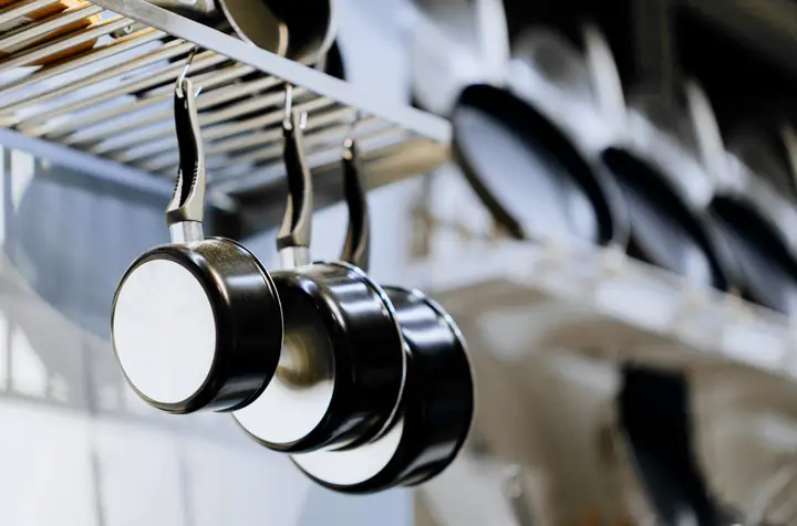 Ollas colgadas de un riel en una cocina