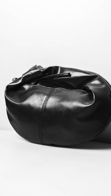 Bolso de cuero negro sobre un fondo blanco