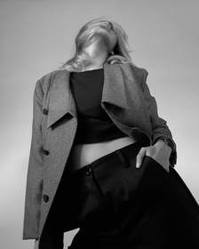 Chaqueta de tweed sobre una blusa negra, sin rostro, en blanco y negro