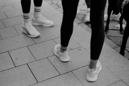 Piernas y zapatillas sobre baldosas grises