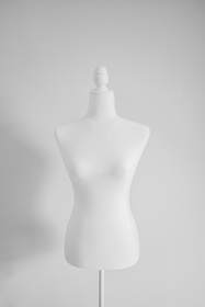 Maniquí de costura blanco sobre un fondo gris claro