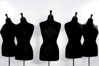 Cinco maniquíes de costura negros en fila