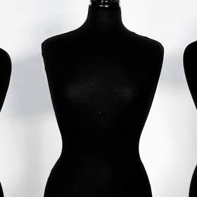 Cinco maniquíes de costura negros en fila
