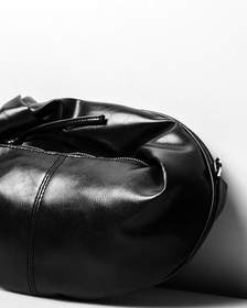 Bolso de cuero negro sobre un fondo blanco
