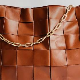 Bolso de cuero trenzado con una cadena dorada