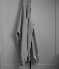 Sudadera gris colgada de una puerta, en blanco y negro