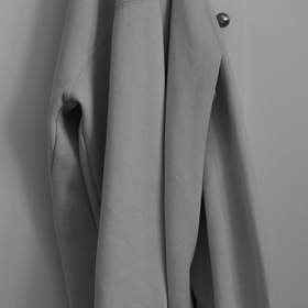 Sudadera gris colgada de una puerta, en blanco y negro