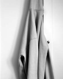 Sudadera gris colgada de una puerta, en blanco y negro