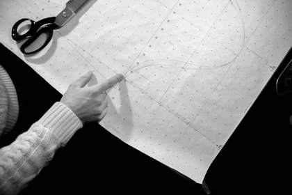 Manos sobre un patrón de papel, en blanco y negro