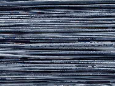 Pila de periódicos en tonos azulados vista de canto