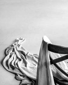 Tela gris colgada sobre el respaldo de una silla de madera