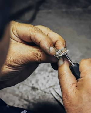Manos que limpian un anillo antiguo en el banco de trabajo.