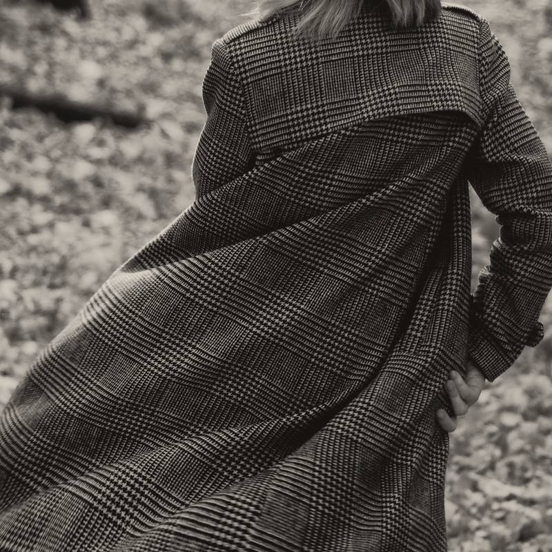 Un abrigo largo de espiga sacudido por el viento, en blanco y negro cálido