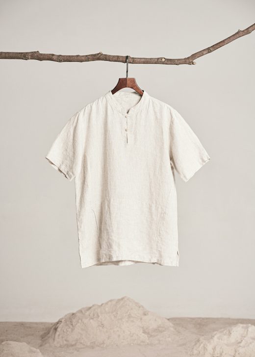 Camisa de lino crudo con cuello mao colgada de una rama