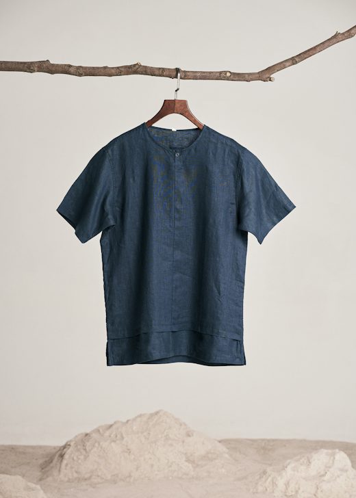 Camisa de lino azul marino colgada de una rama