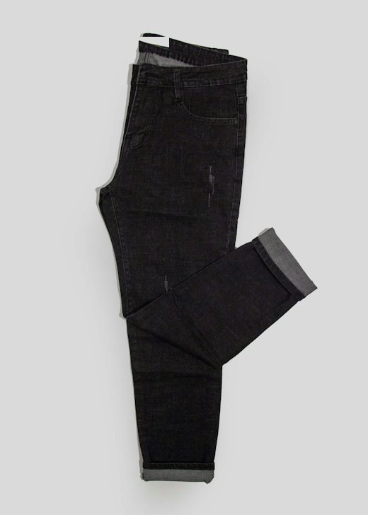 Pantalón de mezclilla oscura doblado sobre un fondo gris claro