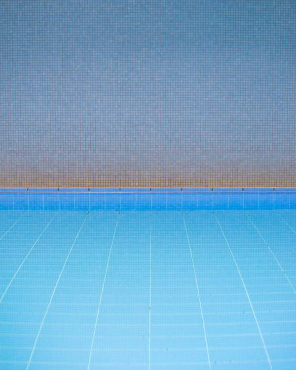 Piscina de baldosas celestes y un cielo difuso
