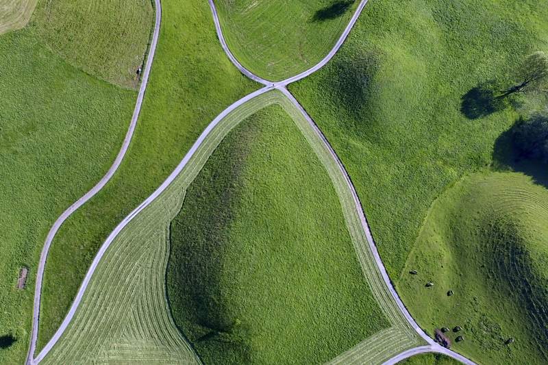 Vista aérea de lomas de hierba atravesadas por caminos que dibujan anillos