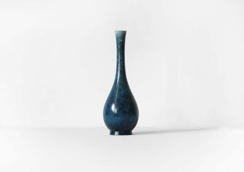 Jarrón azul de cuello largo sobre fondo blanco