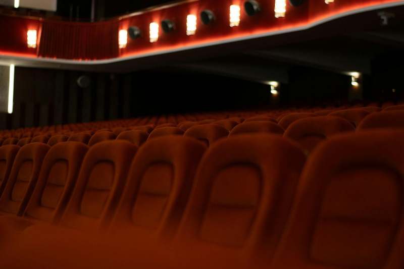 Filas de butacas rojas vacías en una sala de cine