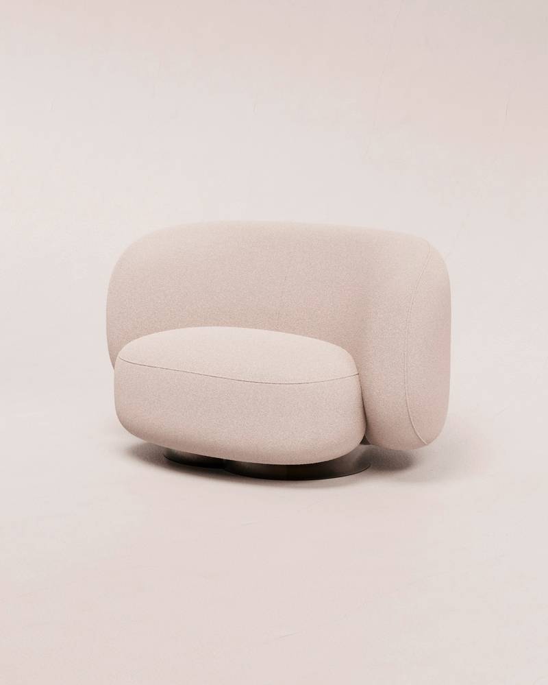 Sillón redondo de tela blanca sobre un fondo crema
