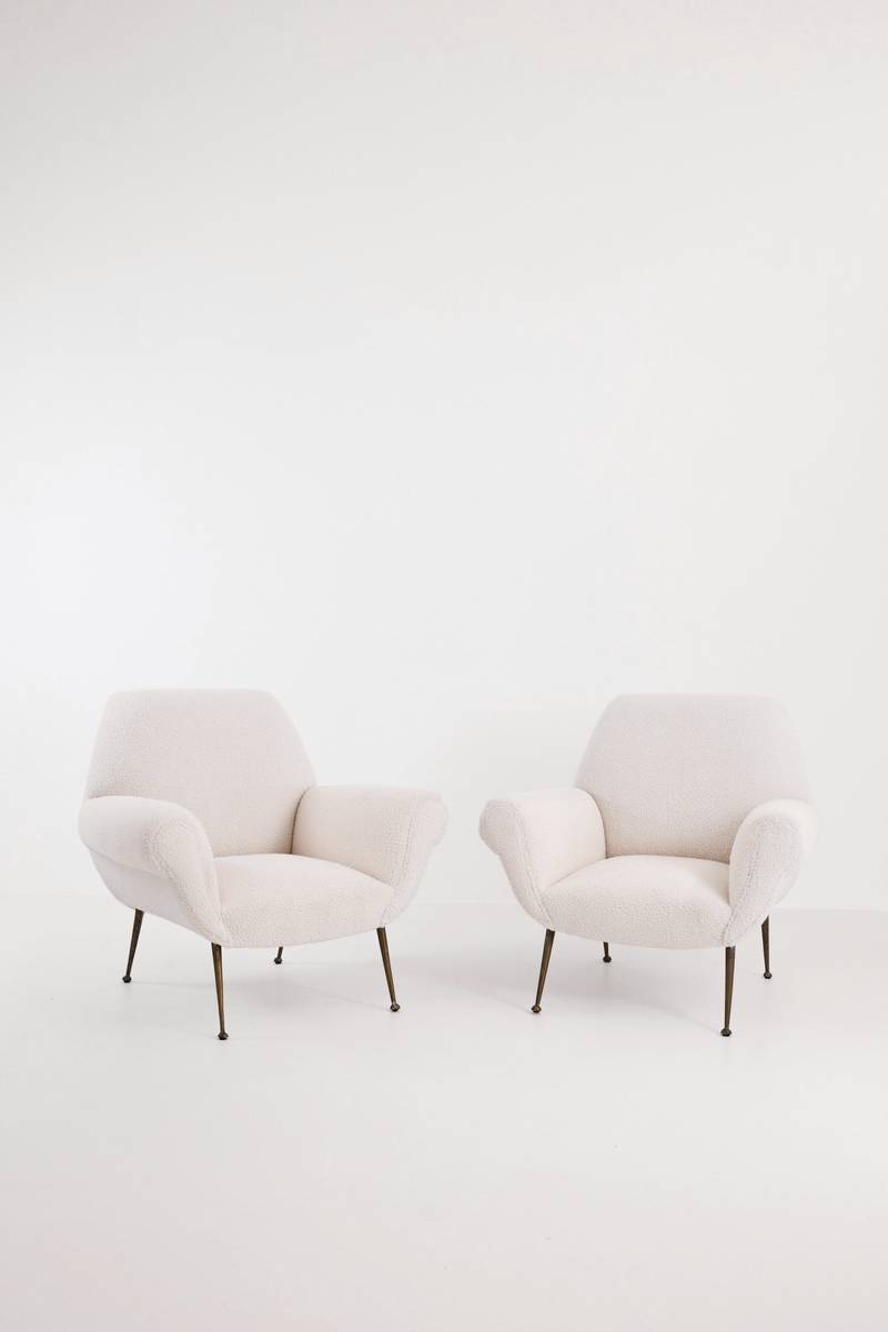 Dos sillones blancos de bordes redondeados sobre un fondo claro