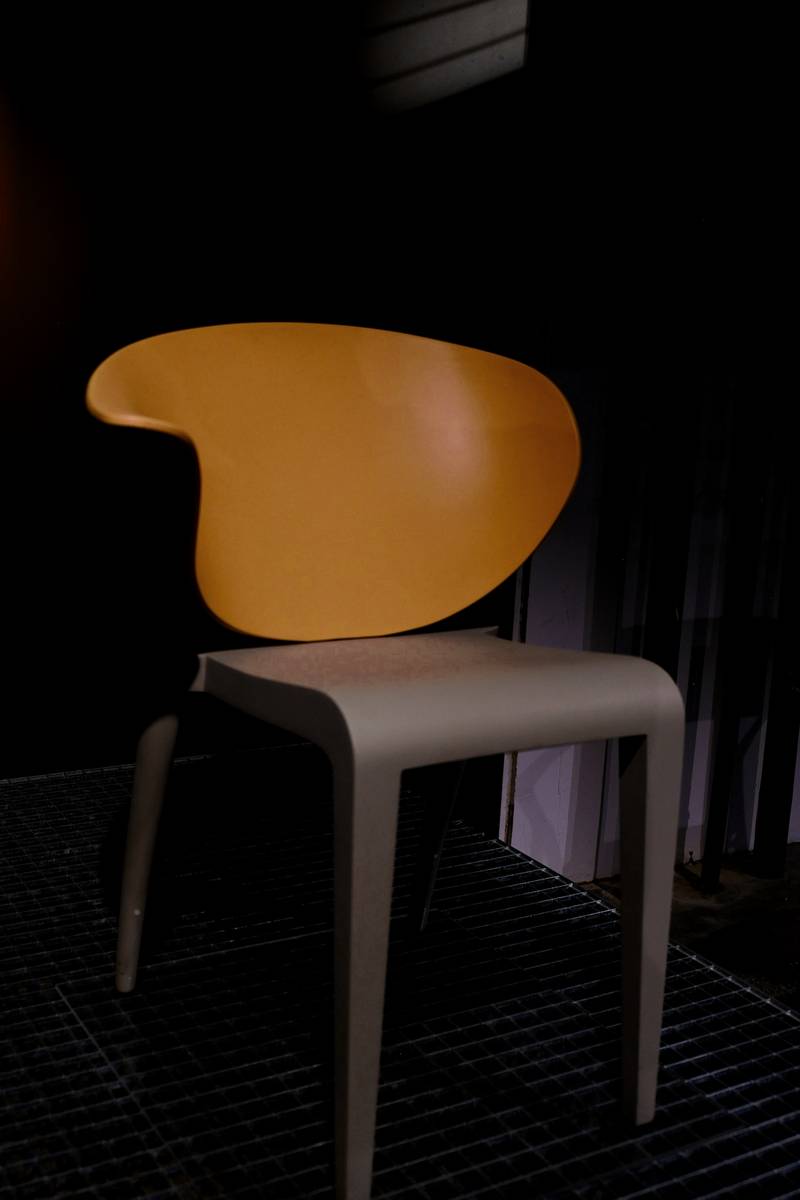 Silla de asiento color miel sobre un fondo oscuro