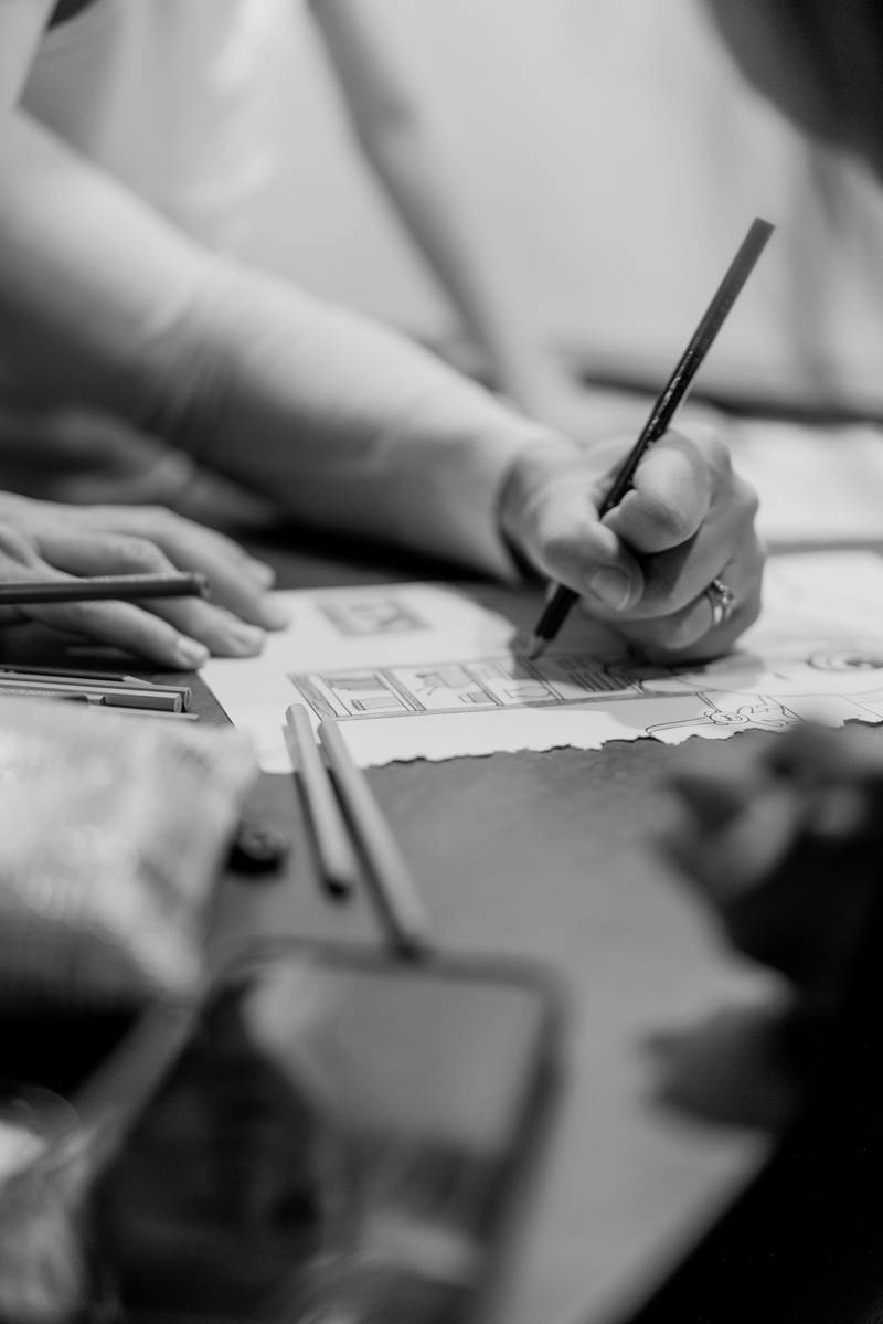 Manos dibujando sobre un plano, en blanco y negro